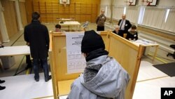 Voters cast their ballots at a school in Espoo, Finland, January 22, 2012.