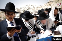Ultra-Orthodox Jewish worshippers take part in the priestly blessing prayer on the holiday of Passover at the Western Wall in Jerusalem's Old City, April 13, 2017.