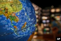 Bola dunia yang menunjukkan negara-negara tenggara di Laut China Selatan dengan klaim sembilan garis putus-putus di bawah wilayah China yang dipajang di sebuah toko buku di Beijing, dalam foto bertanggal 13 Juli 2018. (AP/Andy Wong)