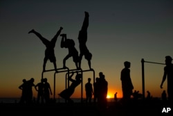 Men exercise in a public gym at a beach in Cadiz, Spain, Aug. 2018. (AP Photo)