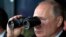 Президент Росії Володимир Путін у бінокль спостерігає за військовими навчаннями поблизу Оренбурга, Росія, 20 вересня 2019. Фото: Прес-служба Кремля, AP