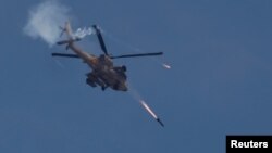 An Israeli military Apache helicopter fires missiles towards Gaza, amid the ongoing conflict between Israel and the Palestinian Islamist group Hamas, as seen from southern Israel, May 14, 2024.