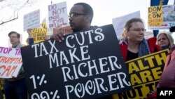 FILE - Demonstrators against a Republican tax reform bill hold a 'People’s Filibuster to Stop Tax Cuts for Billionaires' protest rally outside the US Capitol in Washington, Nov. 30, 2017. 