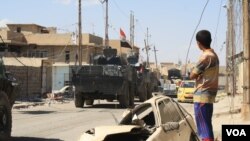 Families look on as Iraqi forces travel to the last few neighborhoods controlled by IS militants in Mosul, Iraq, June 1, 2017. (H. Murdock/VOA)