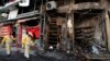 FILE - Municipal workers clean the site of a bomb attack in Baghdad's Karrada district, Feb. 18, 2014.