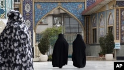 Head-to-toe veiled Iranian women walk at the shrine of Saint Saleh in northern Tehran, April 6, 2021.