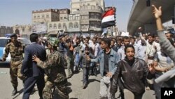 Yemeni police block the way as anti-government protestors attend a rally demanding political reform and the resignation of President Ali Abdullah Saleh in Sanaa, Yemen, February 13, 2011