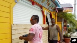 Men board up buildings ahead of Hurricane Maria in Sainte-Anne on the French Caribbean island of Guadeloupe, Monday, Sept. 18, 2017. 