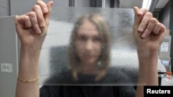 Product design graduate Lucy Hughes holds up a sheet of MarinaTex - an edible and compostable plastic alternative made from byproducts of the fishing industry and other natural ingredients which has won the James Dyson Award, in Brighton, Britain, October