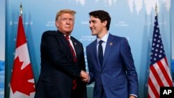 FILE - President Donald Trump, left, meets with Canadian Prime Minister Justin Trudeau during the G-7 summit, June 8, 2018, in Charlevoix, Canada.