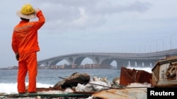FILE - A construction worker looks on as the China-funded Sinamale bridge is seen in Male, Maldives, Sept. 18, 2018.