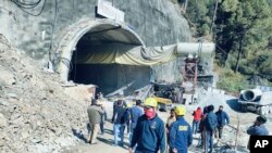 This photo provided by Uttarakhand State Disaster Response Force shows rescuers outside a collapsed road tunnel where more than 30 workers were trapped by a landslide in northern in Uttarakhand state, India, Nov.12, 2023. 