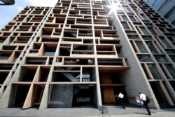 Visitors enter the Wood Hall building featuring its geometric patterns at downtown Tokyo, Aug. 22, 2017.