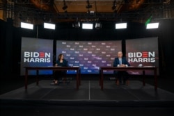 FILE - Democratic presidential candidate former Vice President Joe Biden and running mate Sen. Kamala Harris, sign documents for receiving the Democratic nomination for President and Vice President of the United States in Wilmington, Aug. 14, 2020.