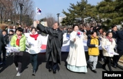 South Korean President Moon Jae-in and his wife Kim Jung-Sook march with participants during a ceremony celebrating the 99th anniversary of the March First Independence Movement against Japanese colonial rule in Seoul, South Korea, March 1, 2018.