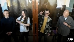 Dari kiri: Konstantin Gabov, Antonina Kravtsova (Favorskaya), Artyom Kriger dan Sergei Karelin berdiri di belakang dinding kaca kandang bagi para terdakwa, saat mereka menghadiri sidang di pengadilan Nagatinskiy di Moskow hari Rabu 2 Oktober 2024.