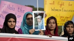 Para perempuan Pakistan membawa poster Malala Yousufzai dalam unjuk rasa mengecam serangan Taliban di Islamabad (13/10).