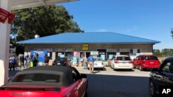 Media, at left, record people entering the KC Mart in Simpsonville, S.C., on Oct. 24, 2018, after it was announced the winning Mega Millions lottery ticket was purchased at the store. 