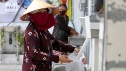 Một phụ nữ nhận gạo từ máy ATM ở TP. Hồ Chí Minh, ngày 11/04/2020.