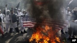 Para demonstran yang marah membakar bendera Amerika di luar Kedutaan Besar AS di Jakarta. Para demonstran juga melemparkan bom-bom molotov dalam aksi hari Senin (17/9).