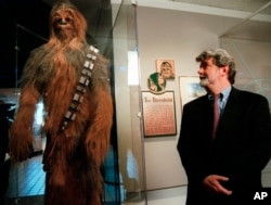 FILE - In this Oct. 29, 1997 file photo, filmmaker George Lucas looks over a Chewbacca costume at the "Star Wars" exhibit at the Smithsonian Institution's Air and Space Museum in Washington.