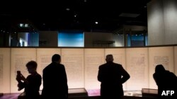 Visitors look at an exhibit about the Dead Sea Scrolls during a media preview of the Museum of the Bible in Washington, D.C., Nov. 14, 2017. 
