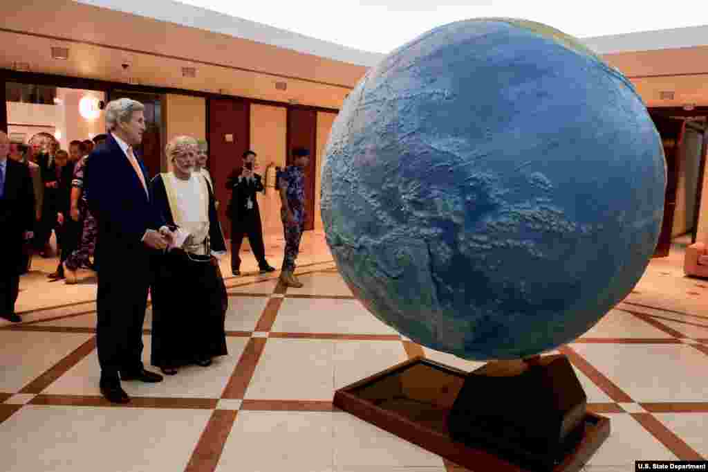U.S. Secretary of State John Kerry and Omani Foreign Minister Yusuf bin Alawi look at a rotating globe at the Ministry of Foreign Affairs in Muscat, Oman.
