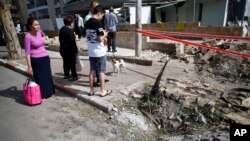 Warga Israel mengamati kerusakan pasca serangan roket oleh militan dari Gaza, Senin 6/5.