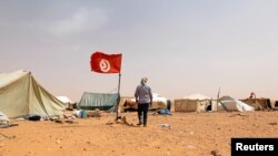 Un protestataire marche près de sa tente lors d'un sit-in à El-Kamour, près de la ville de Tatouine, en Tunisie, le 11 mai 2017.