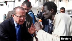 Le représentant spécial de l'U.N. et Chef de la Mission d'appui des Nations Unies en Libye, Martin Kobler écoute un migrant africain lors d'une visite dans un camp de détention à Tripoli, en Libye, le 21 février 2017.