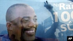 Supporters of incumbent President Joseph Kabila are seen celebrating through a banner with his image after provisional election results are announced in Democratic Republic of Congo's capital Kinshasa, December 9, 2011.