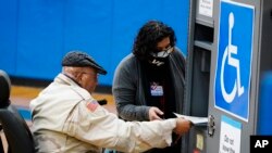 Seorang pemilih memberikan suara mereka dalam pemilihan putaran kedua Senat Georgia, di Atlanta, Selasa, 5 Januari 2021. (Foto AP / Brynn Anderson)
