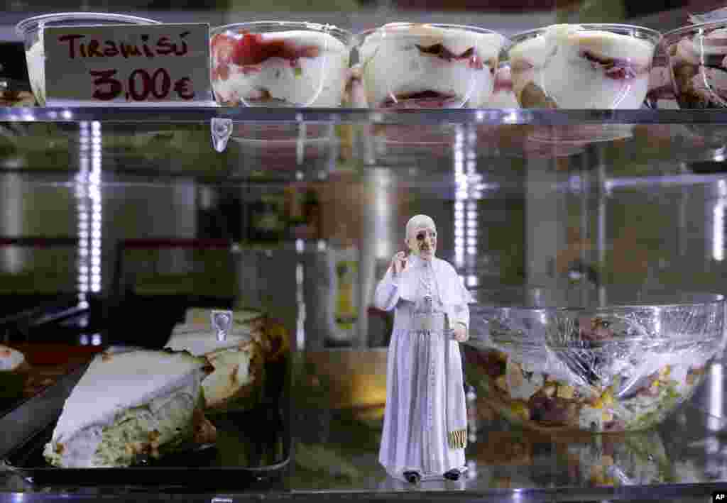 A statuette of Pope Francis is placed among desserts on sale at a cafe, in St. Peter&#39;s Square at the Vatican, April 27, 2014.