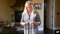 In this Nov. 4, 2019, photo, Tina Chandler looks through her Kukui Nut Lei, as she recalls packing them with a family portrait when she evacuated with during the Kincade Fire, in the Fountaingrove neighborhood of Santa Rosa, Calif. 