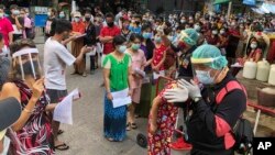 រូបឯកសារ៖ មនុស្សជាច្រើនដែលភាគច្រើនជាពលករចំណាកស្រុកឈរតម្រង់ជួរដើម្បីធ្វើតេស្តរកជំងឺកូវីដ១៩ នៅខេត្ត Samut Sakhon ប្រទេសថៃ កាលពីថ្ងៃទី២០ ខែធ្នូ ឆ្នាំ២០២០។