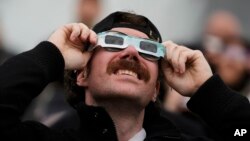 Wani mutum sanye da tabarau din da ake kallon kusufu a Canada (APTOPIX Total Solar Eclipse Canada)