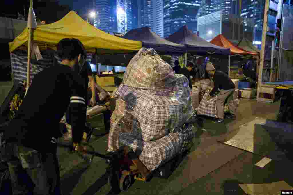 Pro-democracy protesters remove their supplies from outside the government headquarters at the Admiralty district in Hong Kong, Dec. 10, 2014.