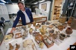 Historic Jamestown senior staff archaeologist David Givens gestures to findings at the site of the Angelo slave house in Jamestown, Va., April 10, 2018.