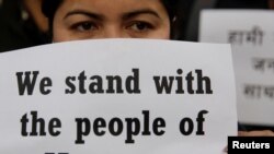 An activist affiliated with Civil Society holds a placard during a protest against Myanmar's military after seizing power from a democratically elected civilian government and arresting its leader Aung San Suu Kyi, in Kathmandu, Nepal, Feb. 1, 2021.