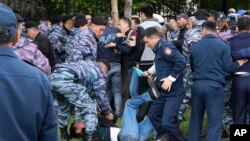 Polisi Kazakhstan menangkap seorang pengunjuk rasa dalam demo anti-pemerintah menentang pilpres di Nur-Sultan, ibu kota Kazakhstan, 9 Juni 2019.