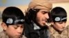 А YouTube screen grab from an Islamic State propaganda video shows an IS recruiter with two child soldiers. Children as young as eight years old are reportedly being trained to serve in roles ranging from spies, to front line soldiers, to suicide bombers.