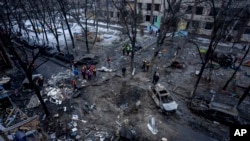 ប្រជាជន​ឈរ​មើល​អគារ​ដែល​ត្រូវបាន​បំផ្លាញ​ដោយសារ​ការវាយប្រហារ​របស់​រុស្ស៊ី​ក្នុង​ទីក្រុង​កៀវប្រទេស​អ៊ុយក្រែន​កាលពីថ្ងៃទី​១៣ ធ្នូ ឆ្នាំ២០២៣។ (AP Photo/Evgeniy Maloletka)
