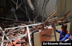 Petugas penyelamat memeriksa puing-puing dari langit-langit yang runtuh di Kuta setelah gempa bumi mengguncang Bali, 13 Oktober 2011. (Foto: REUTERS/Zul Eduardo)