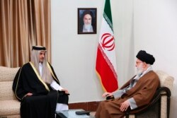 In this photo released by an official website of the office of the Iranian supreme leader, Supreme Leader Ayatollah Ali Khamenei, right, meets Emir of Qatar Sheikh Tamim bin Hamad al-Thani at his office in Tehran, Iran, Jan. 12, 2020. …