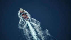 Migrants navigate on an overcrowded wooden boat in the Central Mediterranean Sea between North Africa and the Italian island of Lampedusa, Oct. 2, 2021, as seen from aboard the humanitarian aircraft Seabird.
