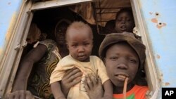 A South Sudanese family waits inside a train in Khartoum to be transported to Wau in South Sudan, March 1, 2012. Last week, 1,700 South Sudanese who lived at Kosti transit camp, south of Khartoum, returned home from the north. 