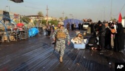 Policeman patrols site of suicide bombing in Doar district of Baghdad, Dec. 19, 2013.