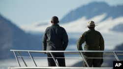 President Barack Obama, accompanied by a National Park Service employee looks at Bear Glacier, which has receded 1.8 miles in approximately 100 years, while on a boat tour to see the effects of global warming in Resurrection Cove, Sept. 1, 2015, in Seward