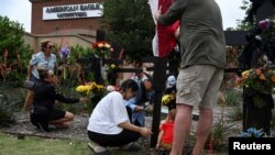 Warga mendirikan tugu peringatan untuk menghormati mereka yang kehilangan nyawa pada hari Sabtu ketika seorang pria bersenjata menembak beberapa orang di mal Allen Premium Outlets di luar Dallas, Texas, AS.