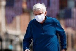 A jogger wears a face mask to protect against the new coronavirus while running through Larimer Square early Saturday, April 25, 2020, in downtown Denver.
